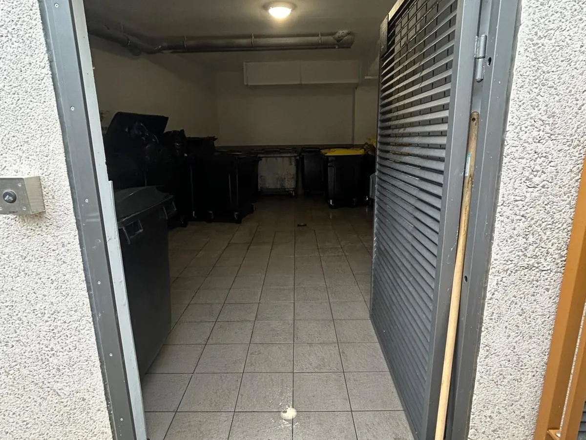 Local poubelles de copropriété nettoyé, conteneurs rangés